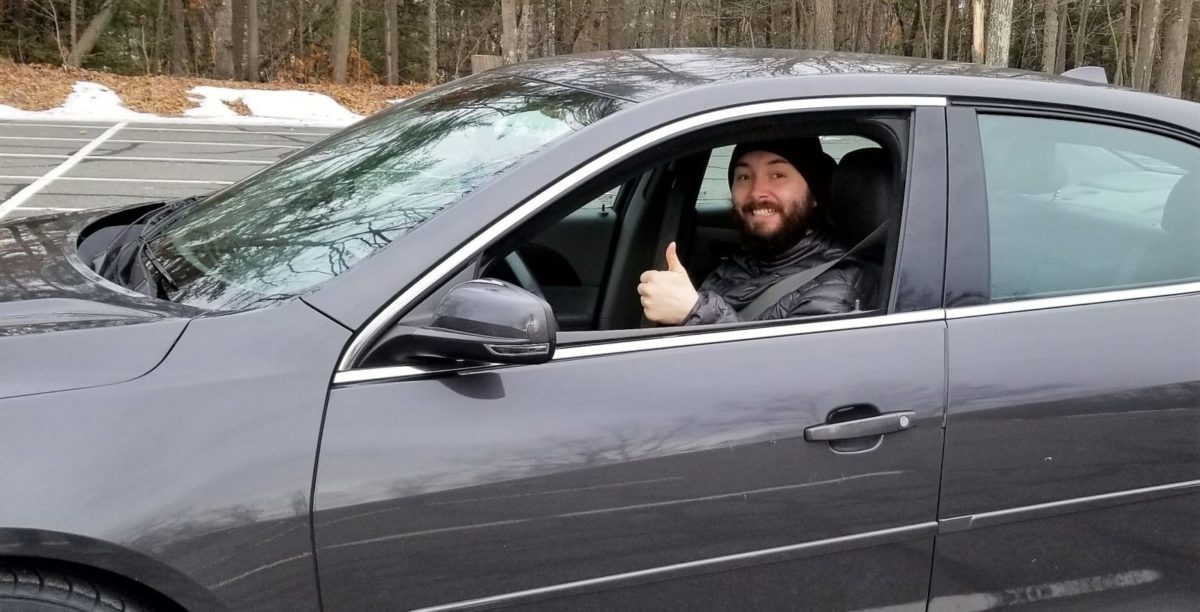 Car recipient Travis Barrett smiles behind the wheel of his new car.