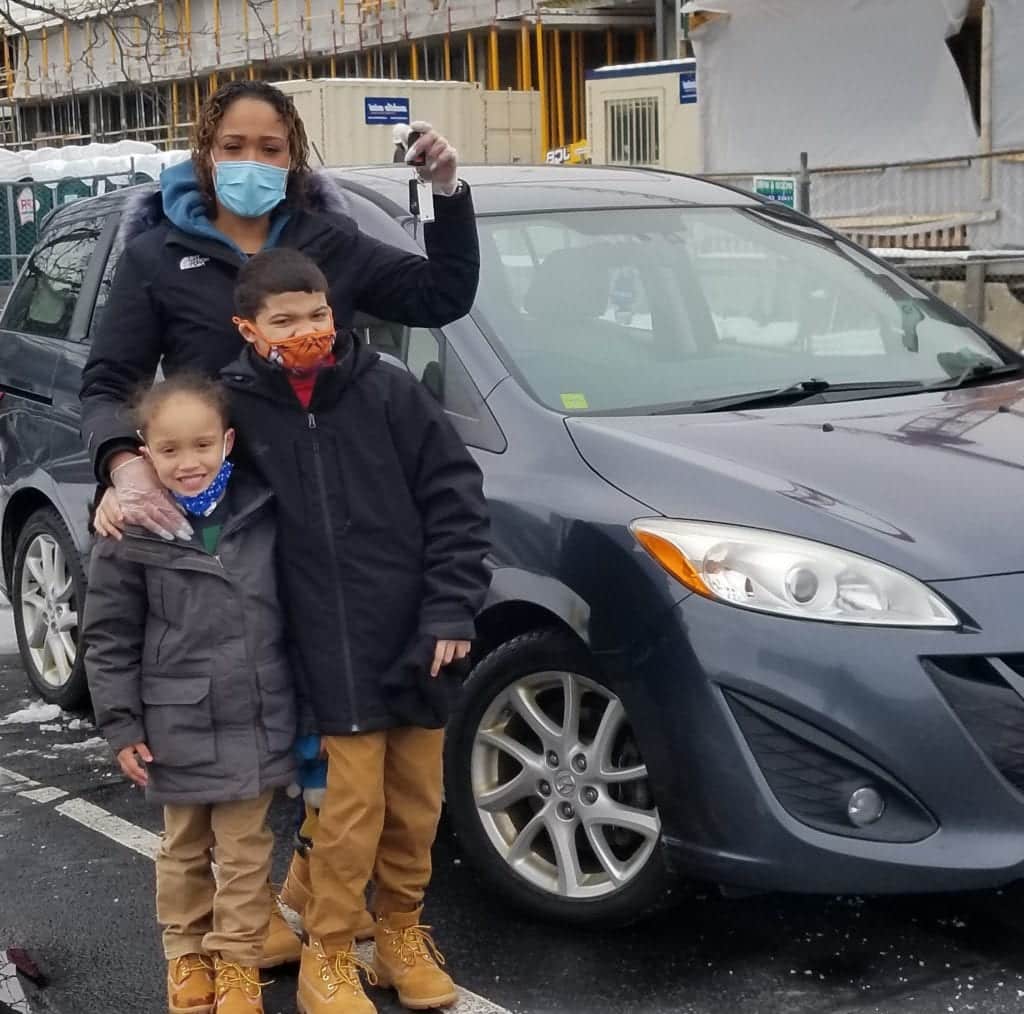 Sedenia poses in front of her new car.