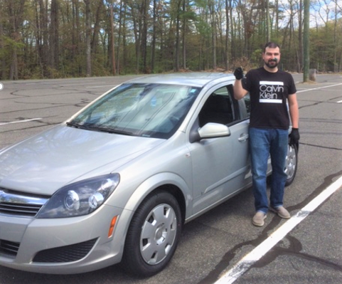 GNG client Jeremy stands in front of his new car.