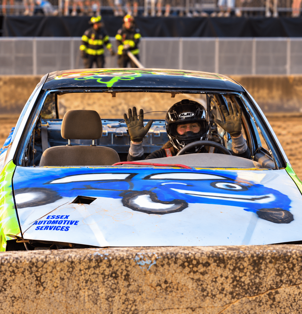 Good News Garage Ready To Go program manager Stephanie Ball Wojtyna sits behind the wheel of her demolition derby car.
